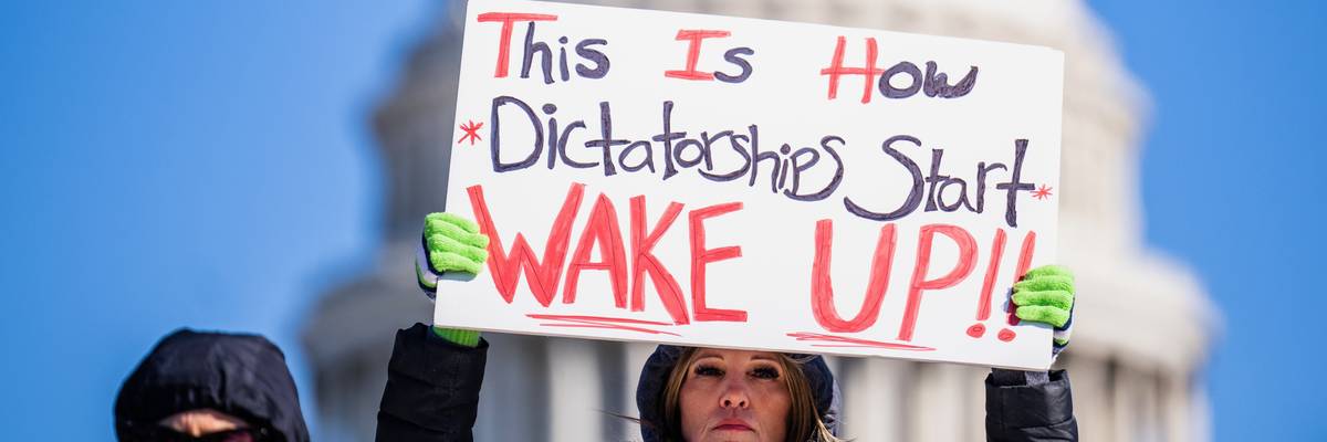 A demonstrator holds a sign during the No Kings Day protest