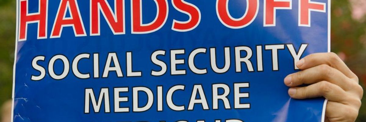 A demonstrator holds a sign opposing cuts to Social Security, Medicare, and Medicaid.