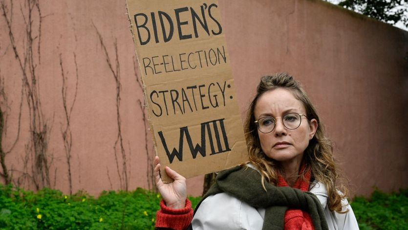 A demonstrator holds a sign that says "Biden's reelection strategy: WWIII"