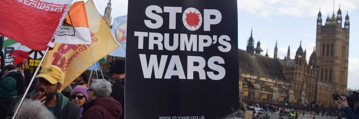 A demonstrator holds a 'Stop Trump's Wars' placard during a...