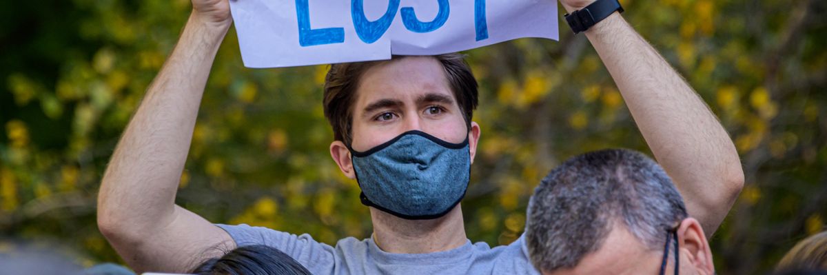 A demonstrator holds sign that says: "Trump Lost."