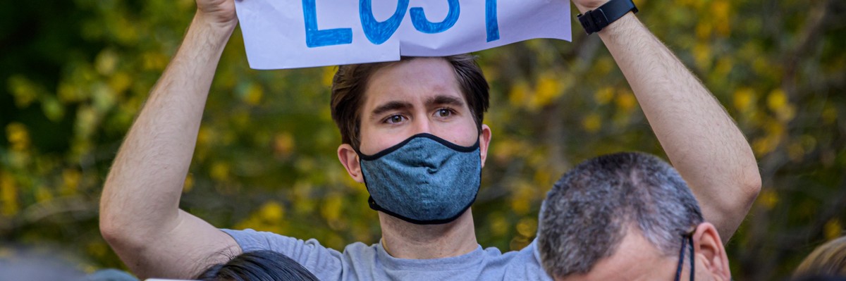A demonstrator holds sign that says: "Trump Lost."