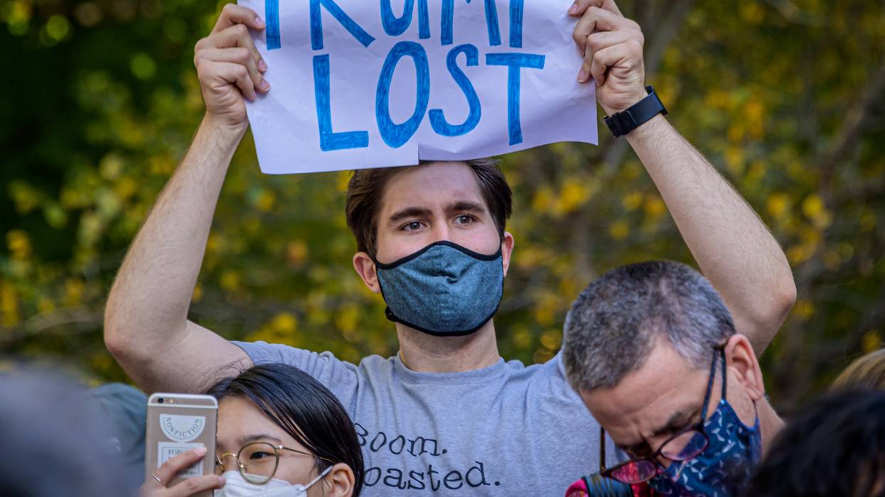 A demonstrator holds sign that says: "Trump Lost."