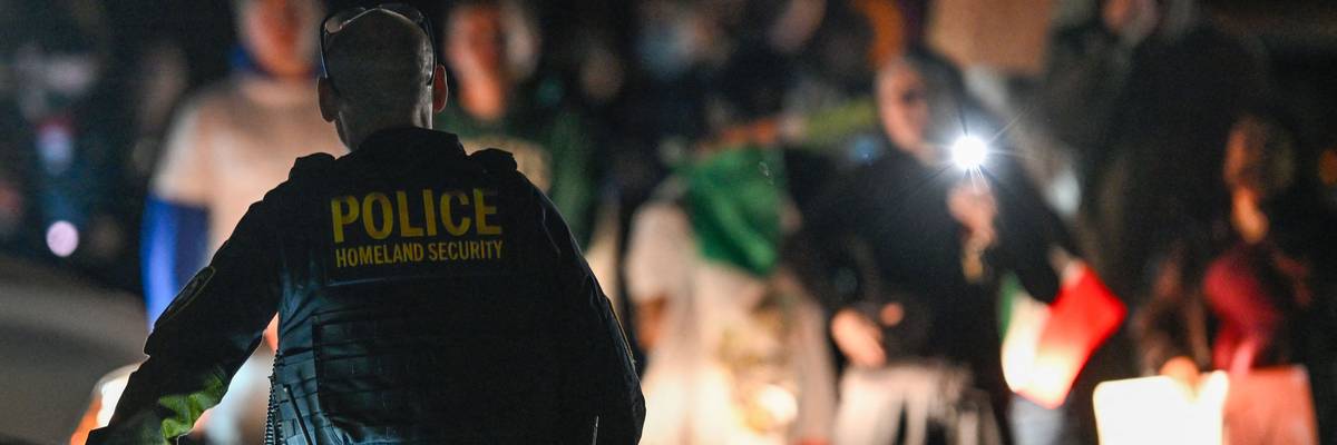 A DHS officer watches a protest.