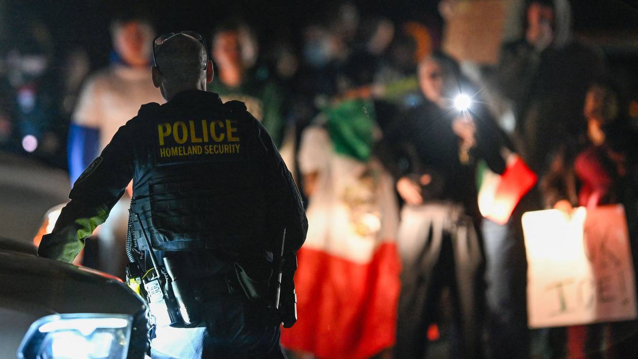 A DHS officer watches a protest.