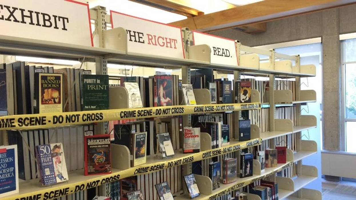 A display of banned books on library shelves.
