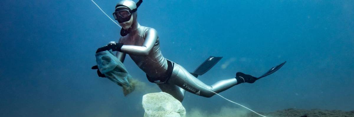 A diver removes plastic from the ocean floor.