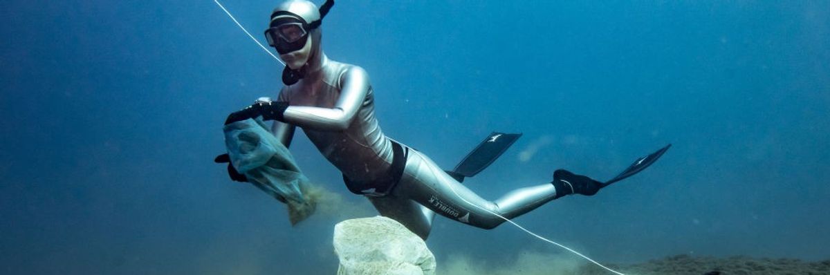A diver removes plastic from the ocean floor.