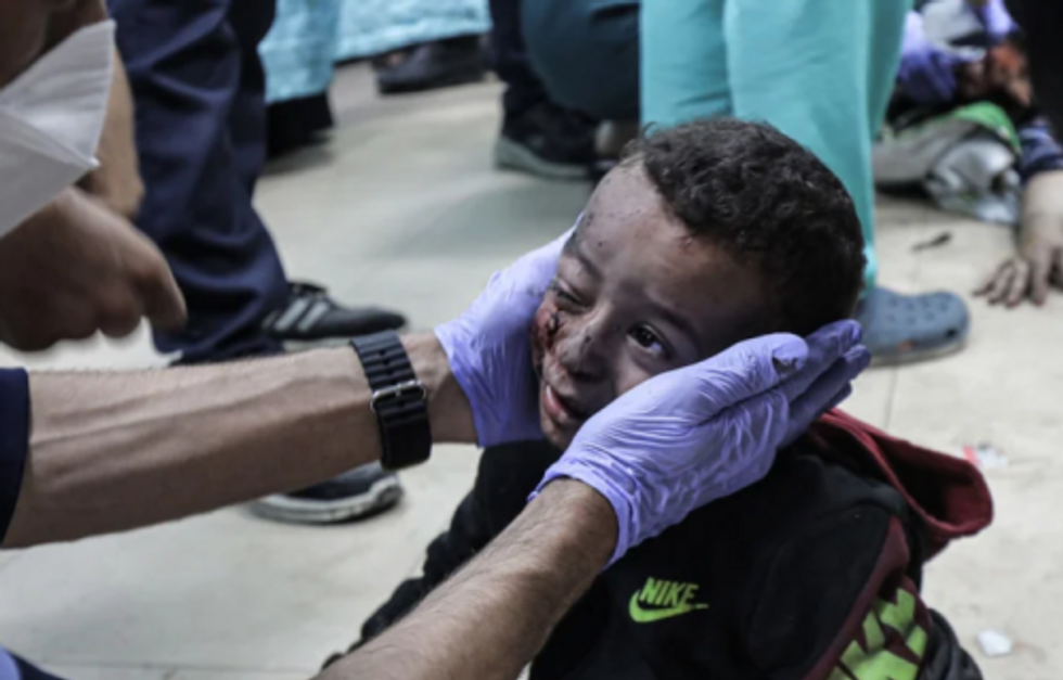 A doctor examines the bloody head of a Gazan child wounded in an Israeli airstrike.