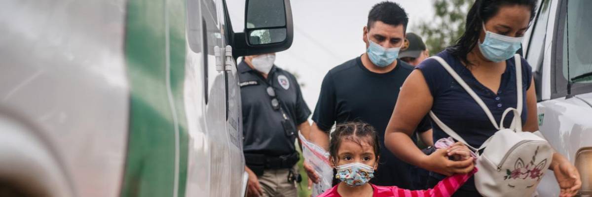 A family is taken to an immigration processing center after crossing the U.S.-Mexico border.