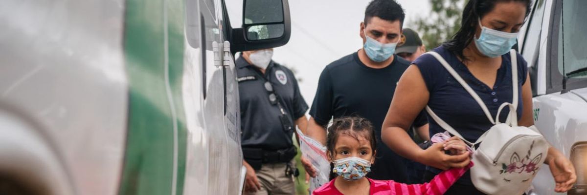A family is taken to an immigration processing center after crossing the U.S.-Mexico border.