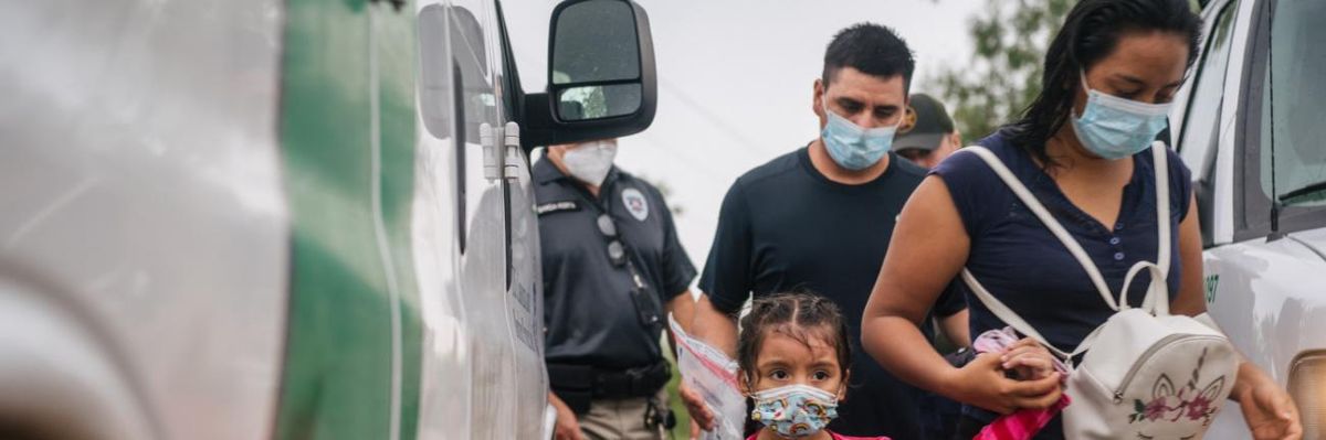 A family is taken to an immigration processing center after crossing the U.S.-Mexico border.