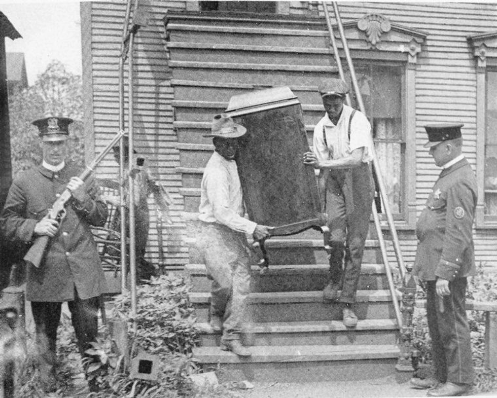A family leaves their damaged home after 1919 Chicago race riot | wikimedia commons / Public Domain