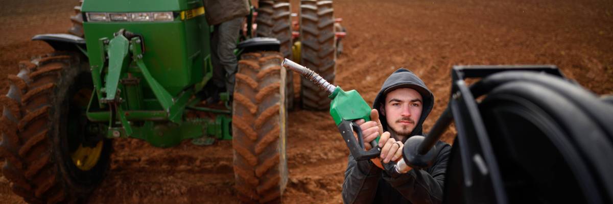 A farmer fuels a tractor