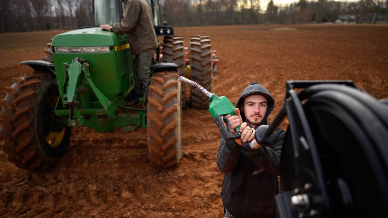 A farmer fuels a tractor