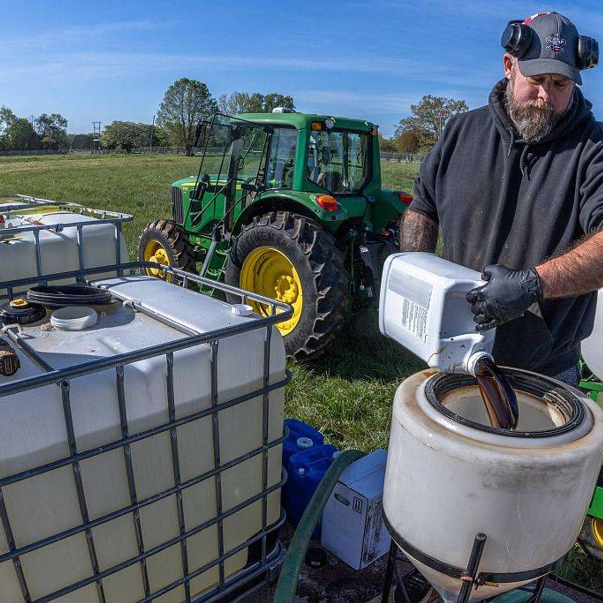 A farmer prepares fertilizer to spray on his fields