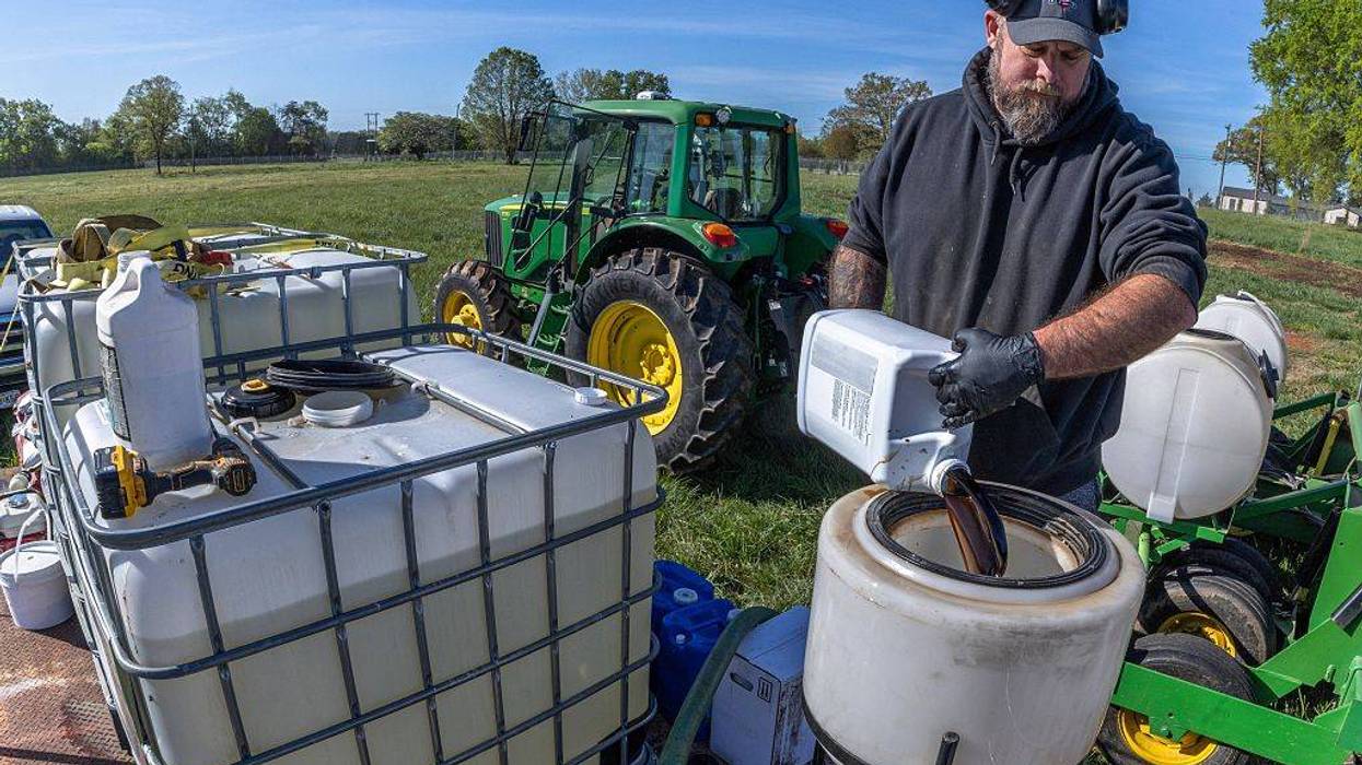 A farmer prepares fertilizer to spray on his fields
