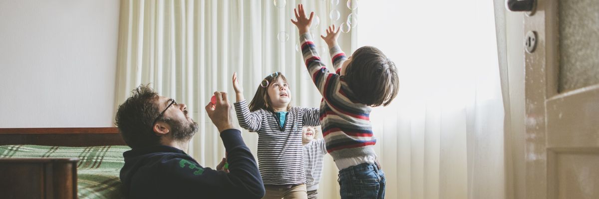 A father plays with his children.