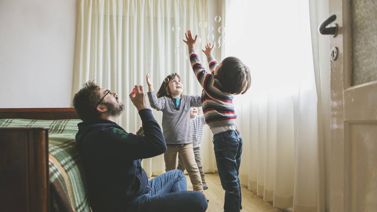 A father plays with his children.