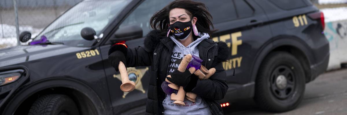 A female protester carries handfuls of dildos