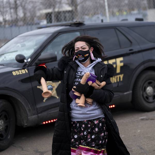 A female protester carries handfuls of dildos