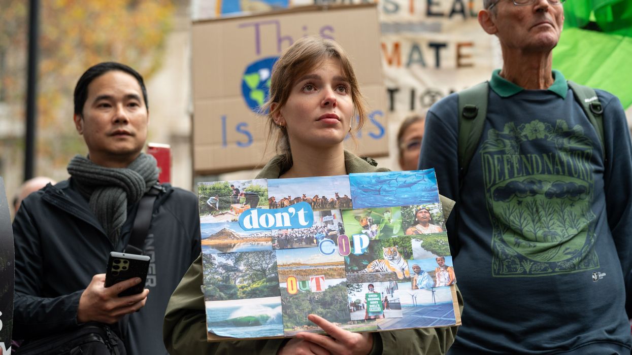 A female protester holds a placard saying "Don't COP out"
