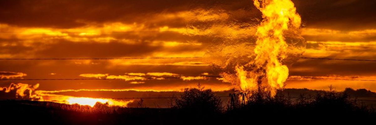A fiery methane flare rises near a well in the Bakken Oil Field.