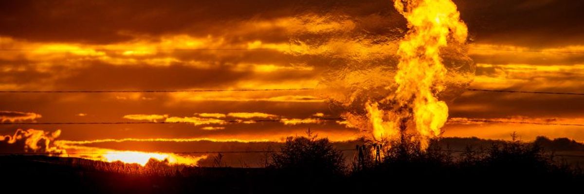 A fiery methane flare rises near a well in the Bakken Oil Field. 