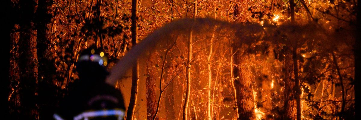 A firefighter combats a wildfire in France