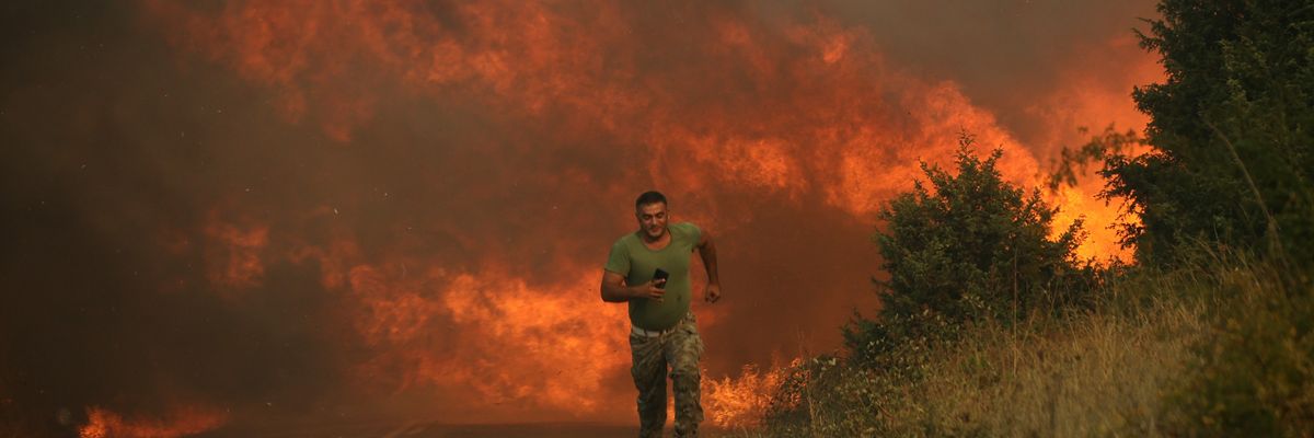 A firefighter runs as a wildfire intensifies