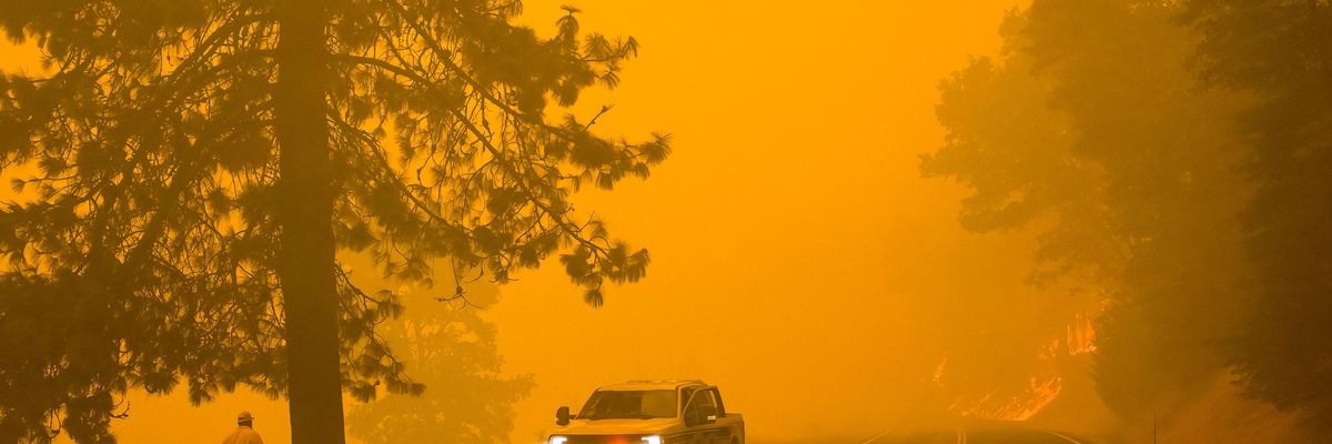 A firefighter turns around as active flames reach highway 70 in California on July 24, 2021. (Photo: Ty O'Neil/SOPA Images/LightRocket via Getty Images)