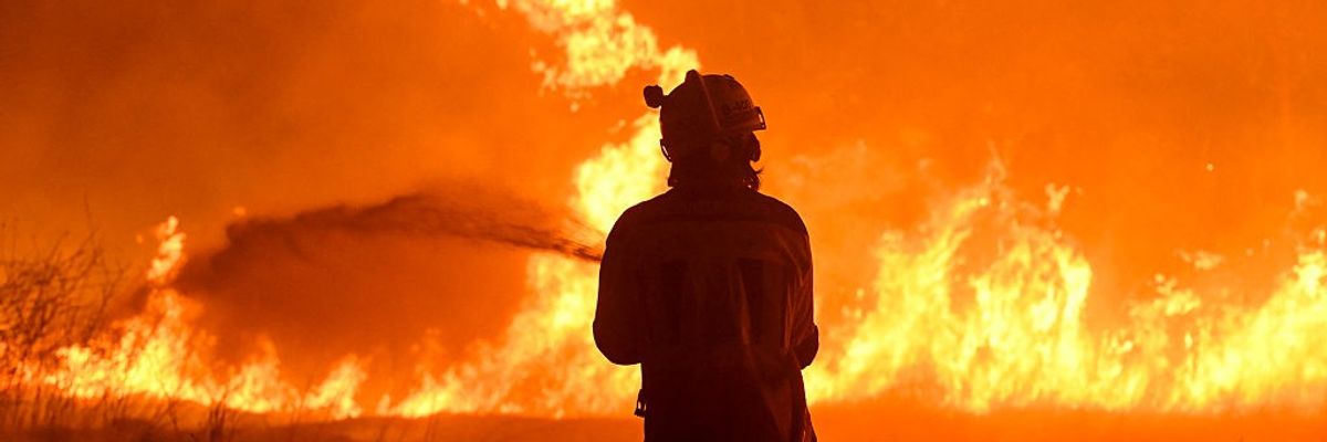 A firefighter works to extinguish a wildfire in the village of Vilaza in northwestern Spain