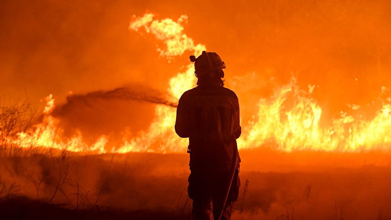 A firefighter works to extinguish a wildfire in the village of Vilaza in northwestern Spain
