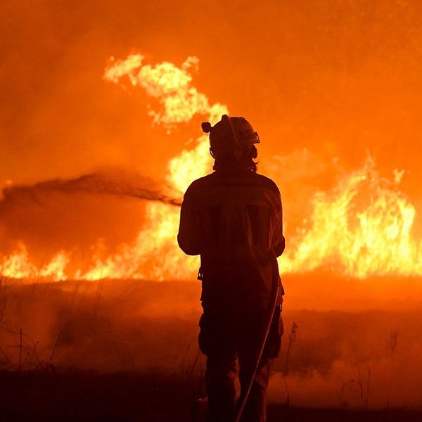 A firefighter works to extinguish a wildfire in the village of Vilaza in northwestern Spain