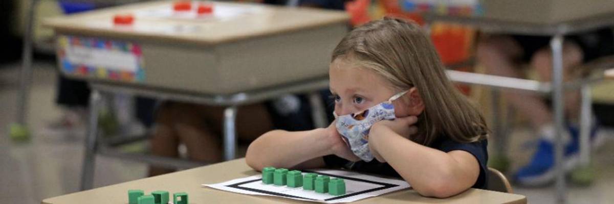 A first grade student sits at her desk at South Boston Catholic Academy in South Boston on September 10, 2020