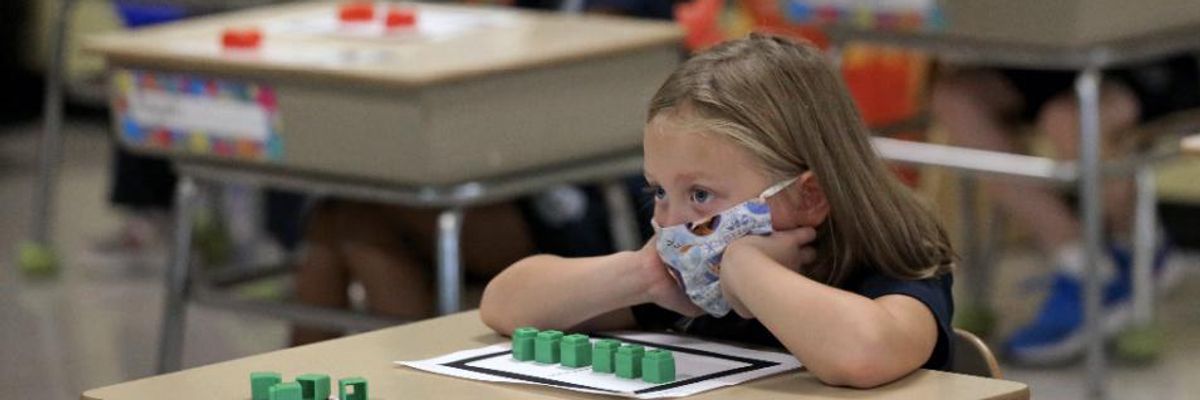 A first grade student sits at her desk at South Boston Catholic Academy in South Boston on September 10, 2020