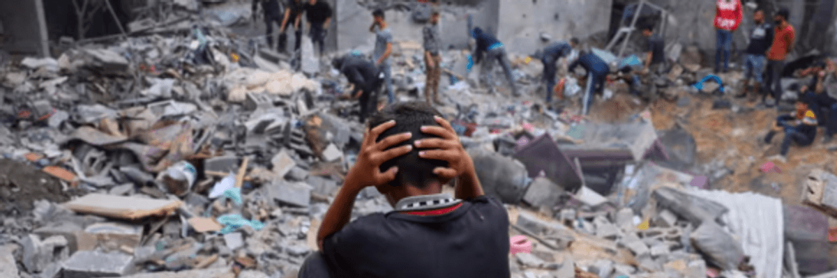 A Gazan child watches as people sort through rubble after an Israeli airstrike on Rafah.