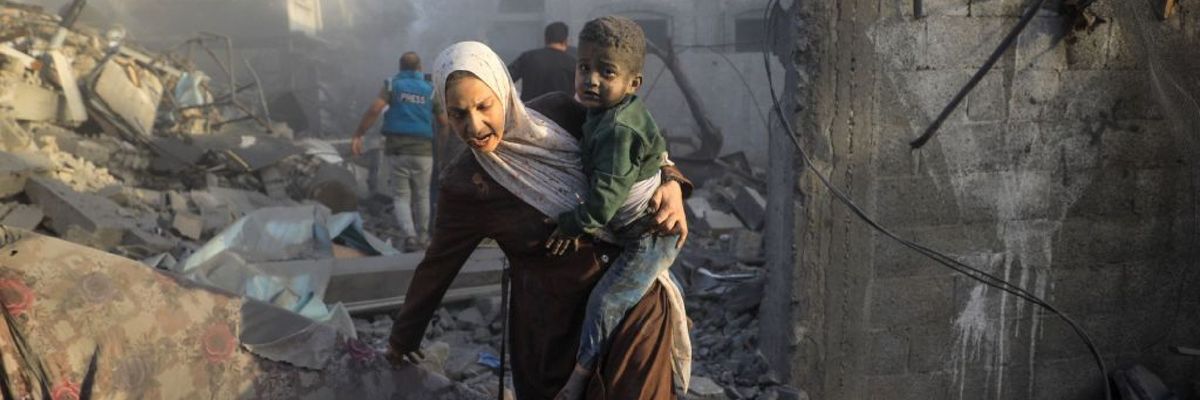 A Gazan mother and  child flee an Israeli airstrike at al-Maghazi refugee camp