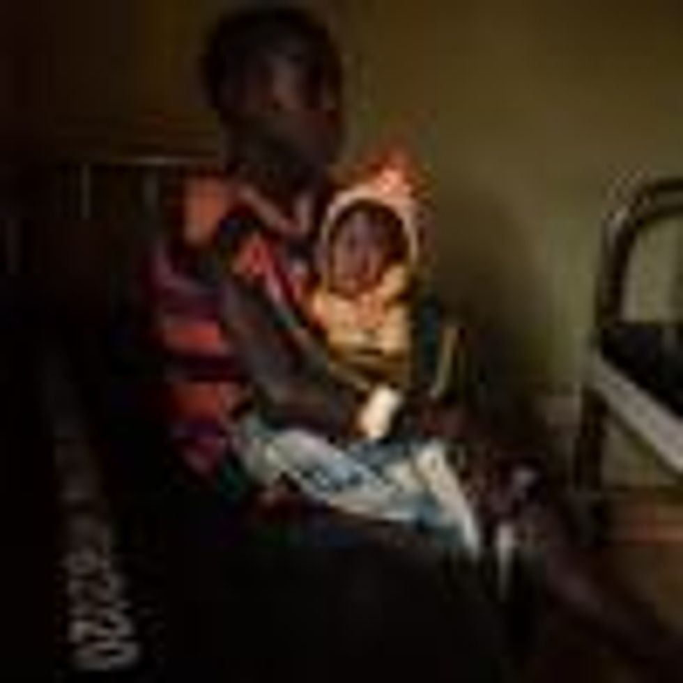 A girl holds her malnourished sister