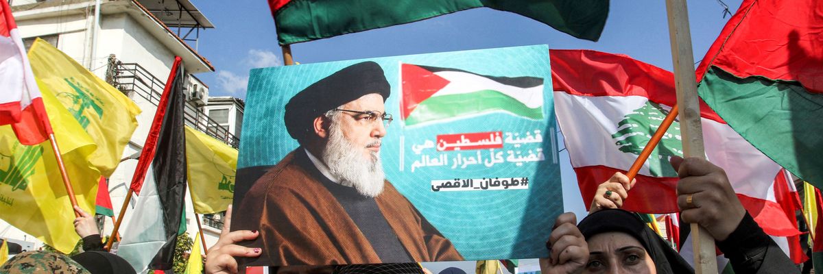 A girl holds up a sign showing Hezbollah leader Hassan Nasrallah at a Palestine solidarity protest in Lebanon.
