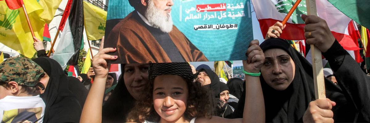 A girl holds up a sign showing Hezbollah leader Hassan Nasrallah at a Palestine solidarity protest in Lebanon.