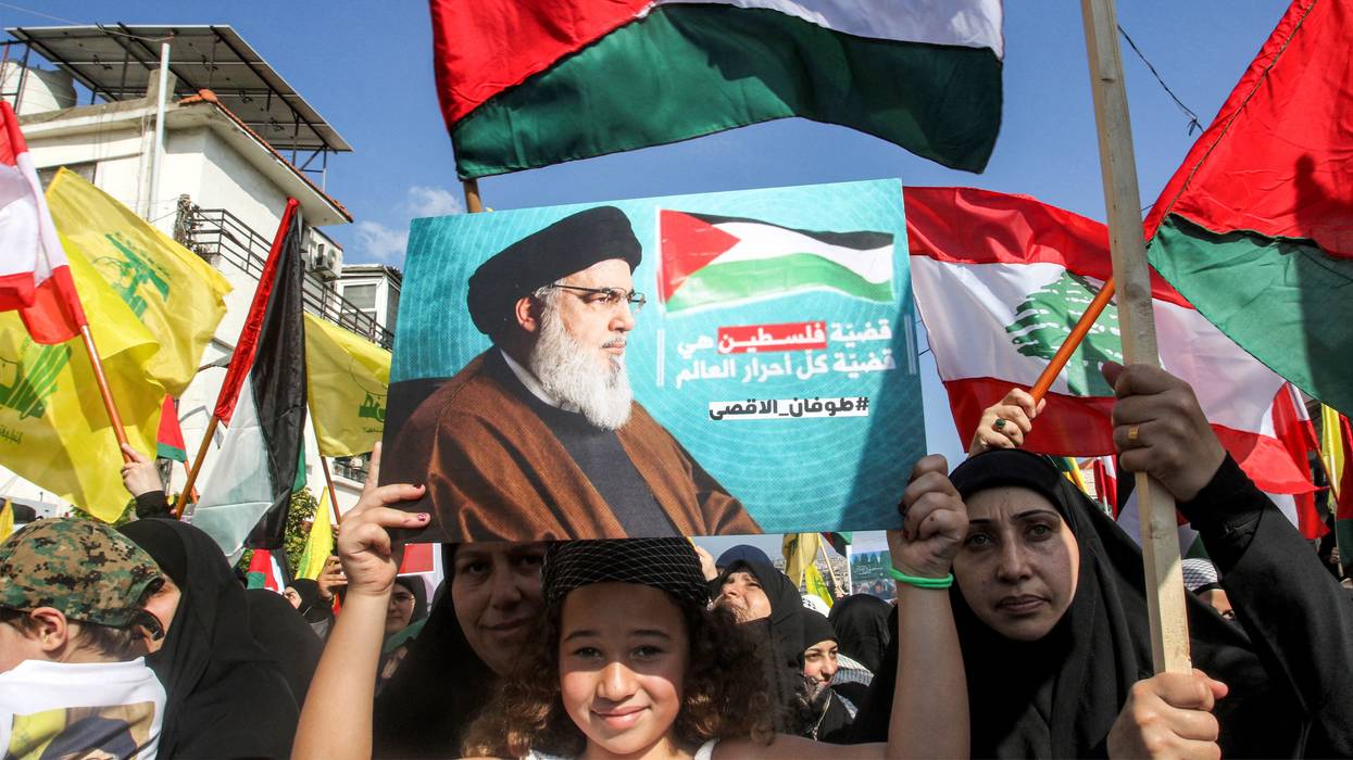A girl holds up a sign showing Hezbollah leader Hassan Nasrallah at a Palestine solidarity protest in Lebanon.