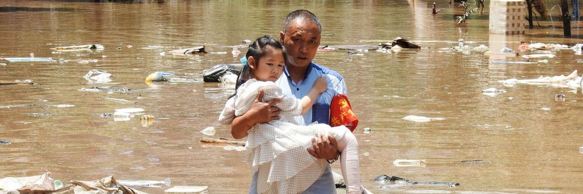 A girl is carried to safety after flooding in southern China