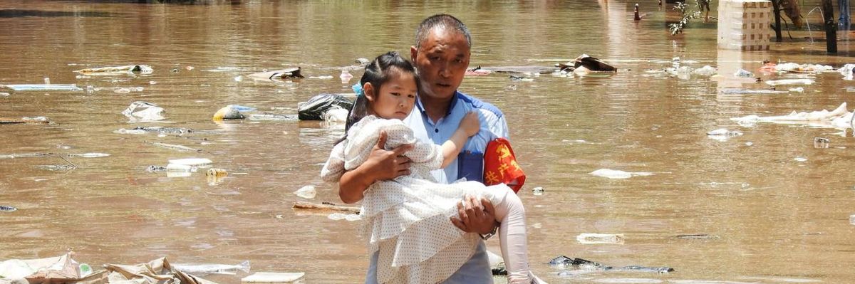 A girl is carried to safety after flooding in southern China