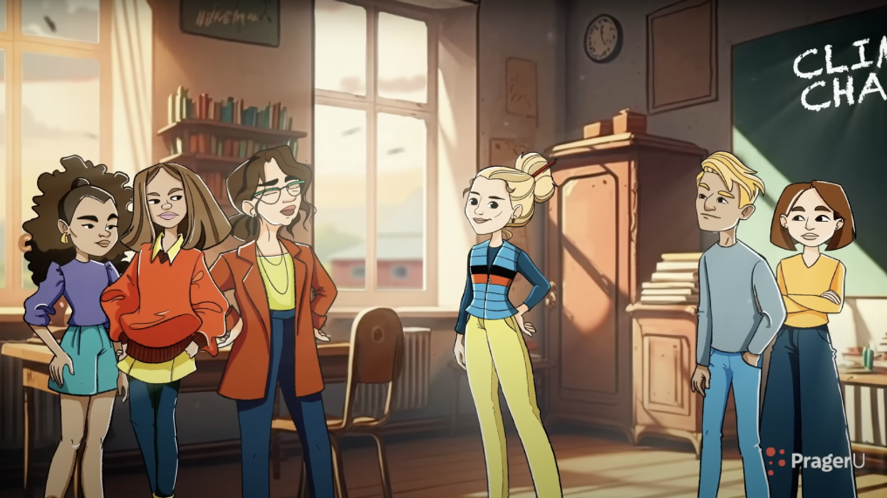 A girl stands in the center of a classroom while other students glare at her.