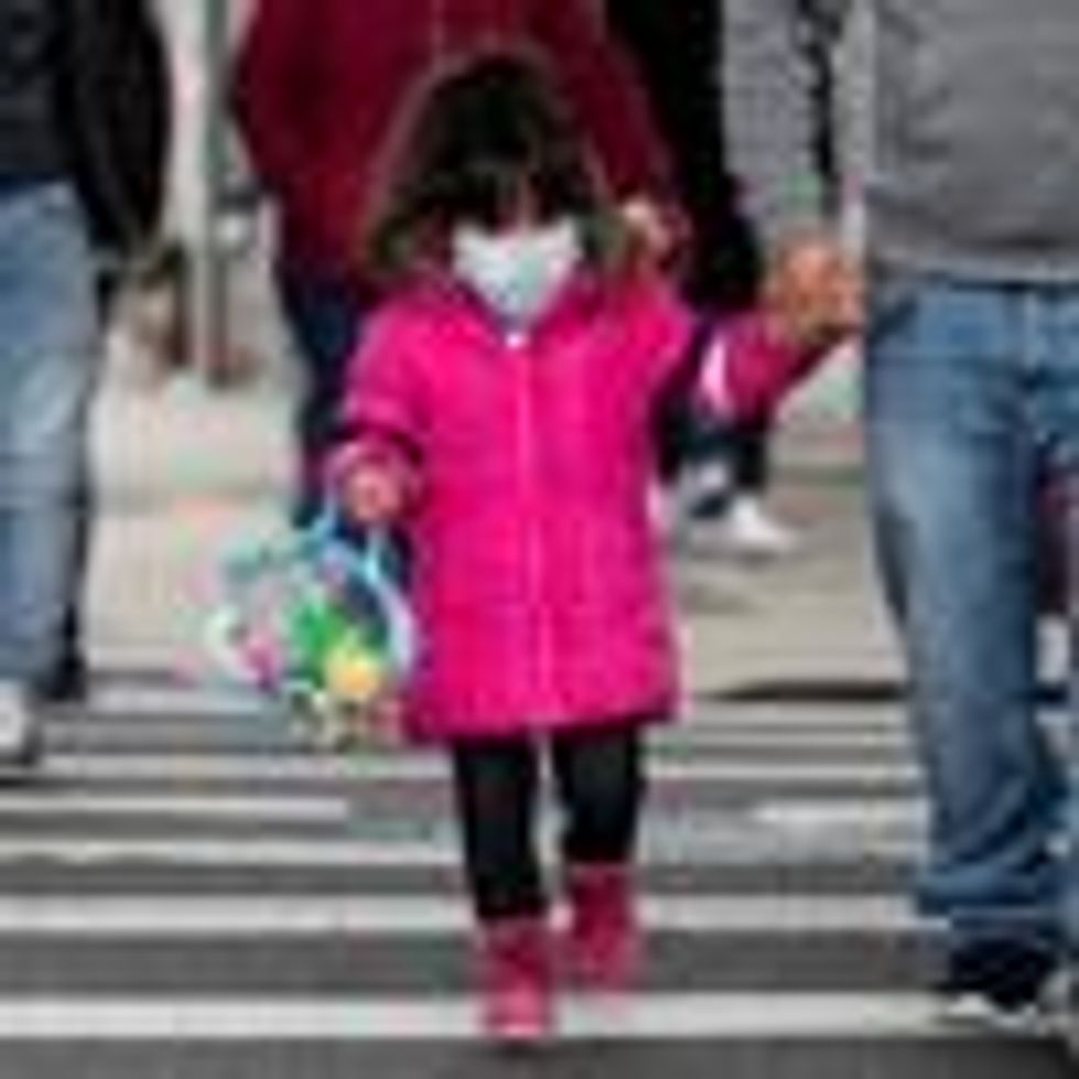 A girl, wearing a mask, walks down a street in the Corona neighborhood of Queens on April 14, 2020 in New York City.