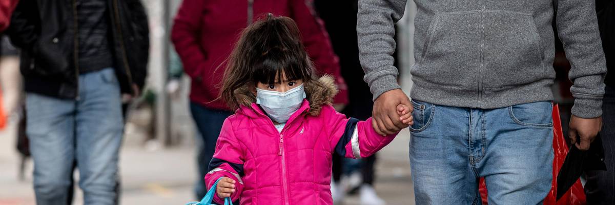 A girl, wearing a mask, walks down a street in the Corona neighborhood of Queens on April 14, 2020 in New York City.