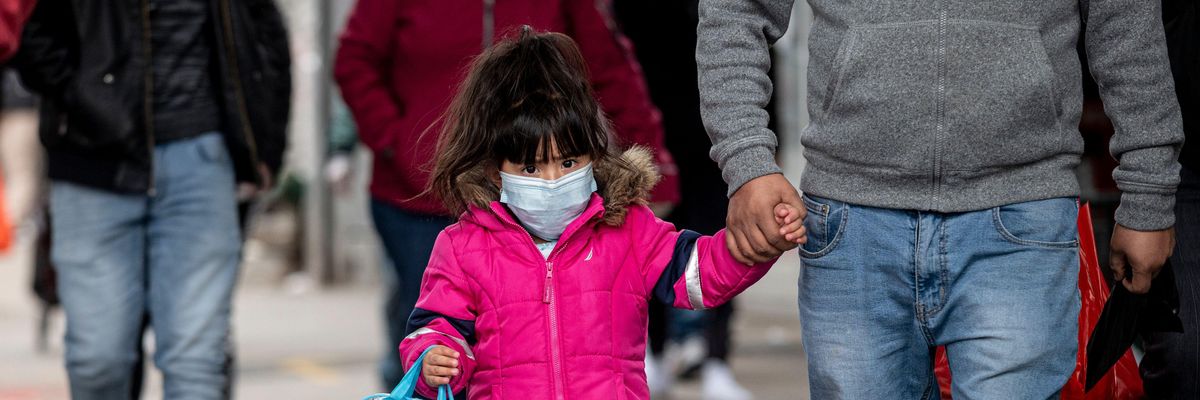 A girl, wearing a mask, walks down a street in the Corona neighborhood of Queens on April 14, 2020 in New York City.