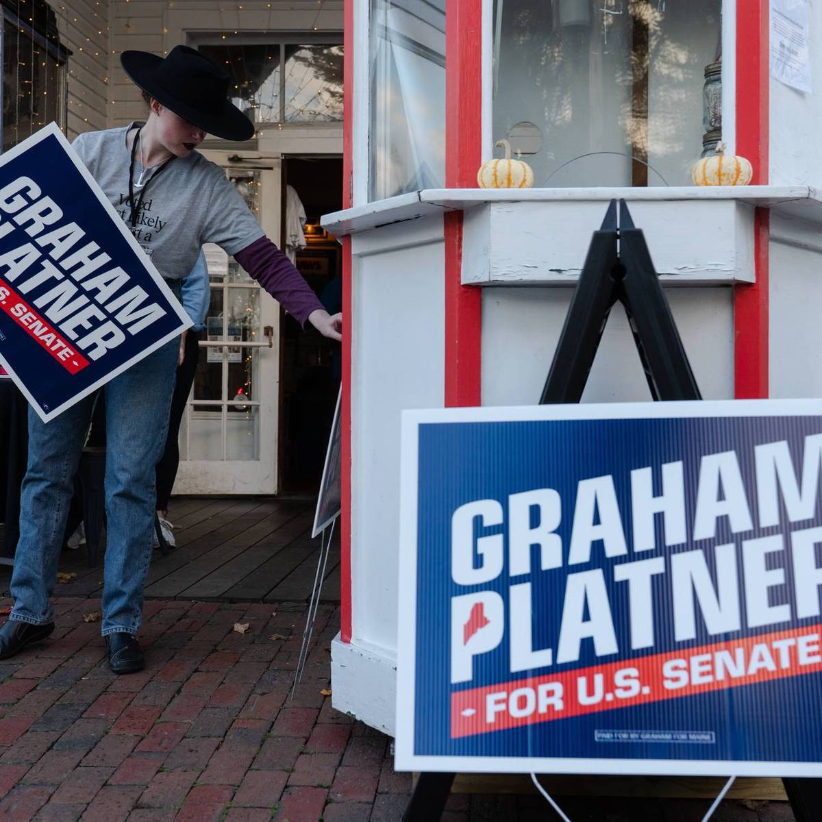 A Graham Platner volunteer holds a campaign sign