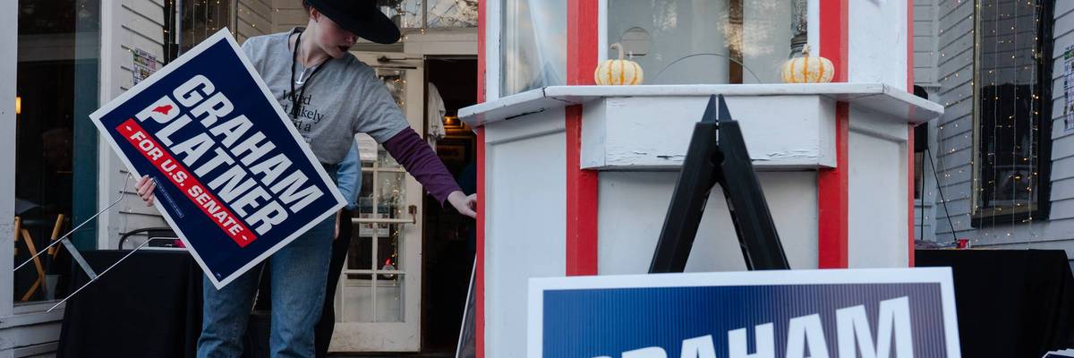 A Graham Platner volunteer holds a campaign sign